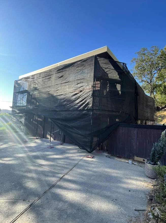 Full perimeter scaffolding with black debris netting installed by Los Angeles Elite Scaffolding for exterior building protection and safety.