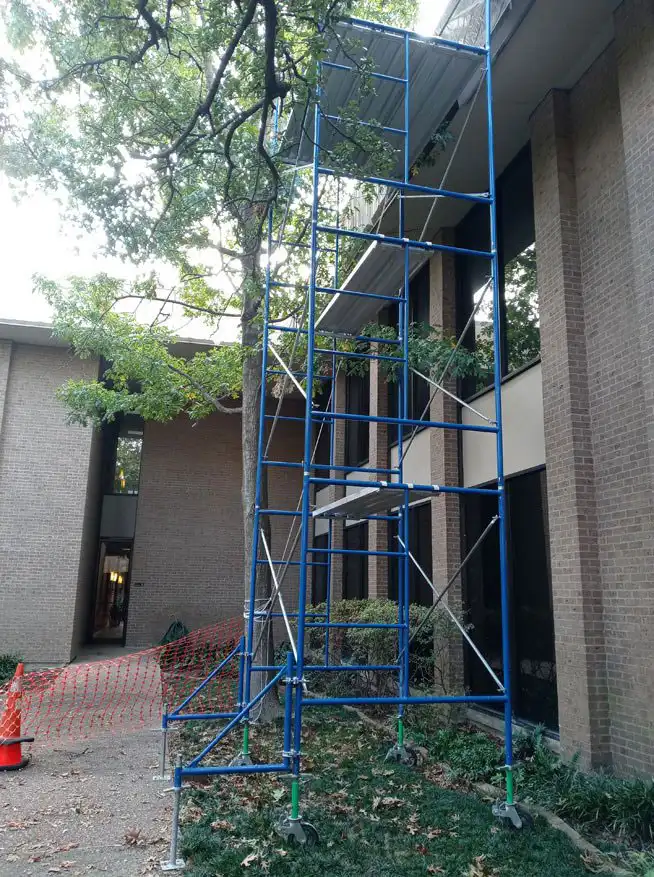 Frame scaffolding system set up on uneven ground by Los Angeles Elite Scaffolding to reach upper floors of a residential building.